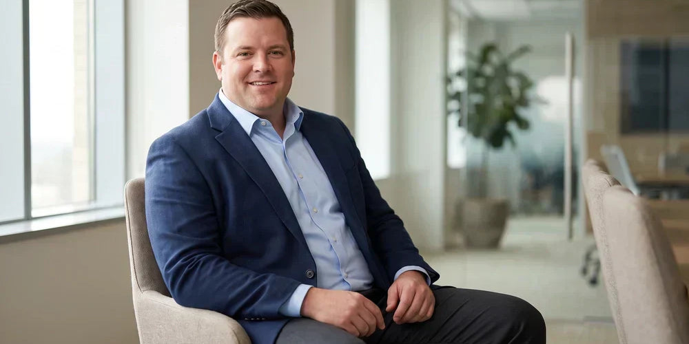 Confident bigger-built man in a well-fitted dress shirt and blazer seated for a job interview