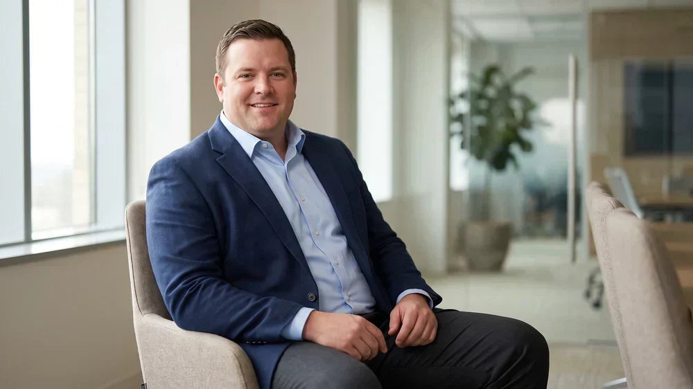 Confident bigger-built man in a well-fitted dress shirt and blazer seated for a job interview