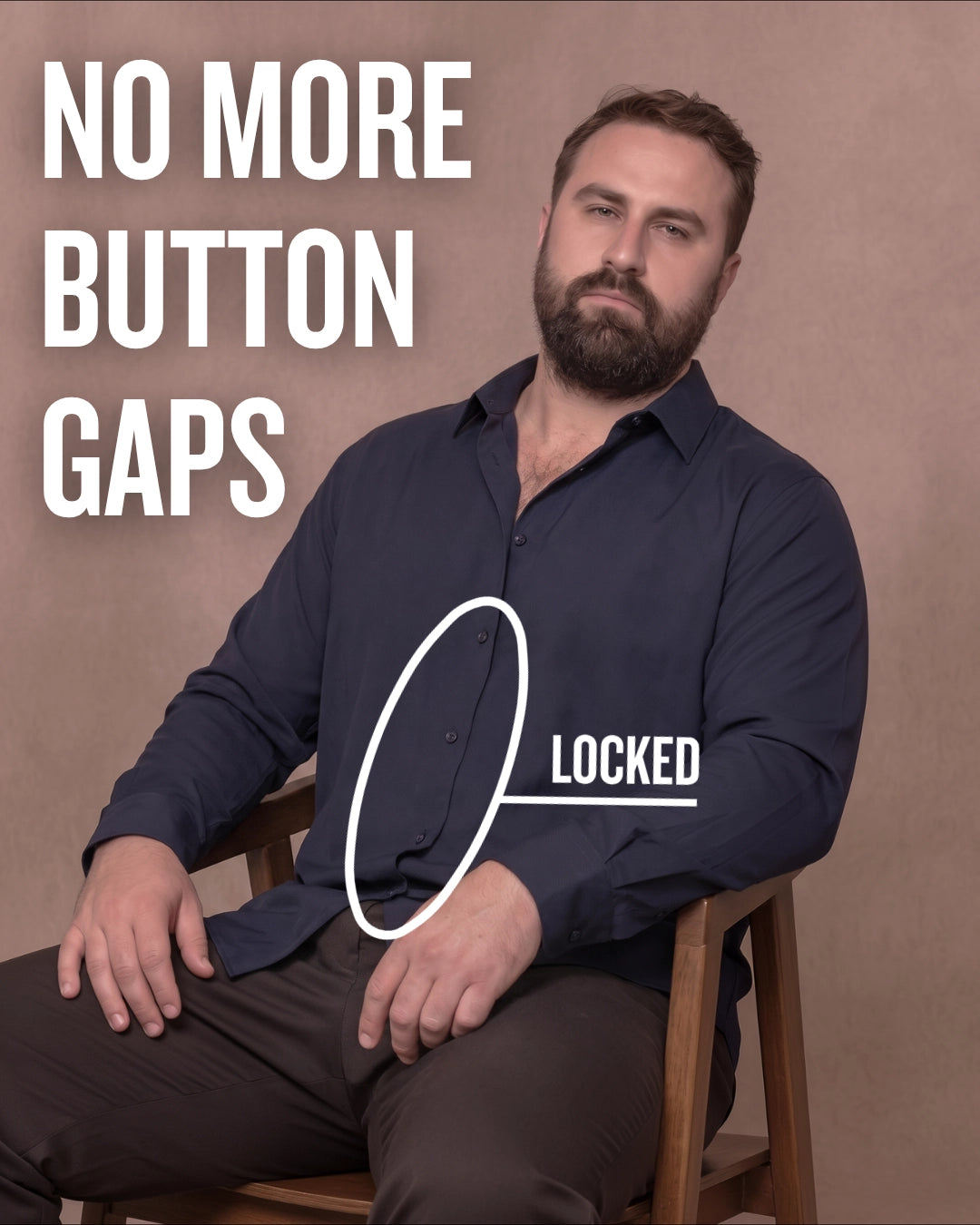 White man sitting on a chair wearing a navy long-sleeve dress shirt, pointing at the button placket to show no button gap, front view