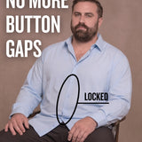 White man sitting on a chair wearing a light blue long-sleeve dress shirt, pointing at the button placket to show no button gap, front view