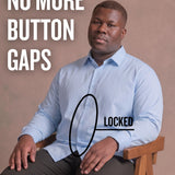 Black man sitting on a chair wearing a light blue long-sleeve dress shirt, pointing at the button placket to show no button gap, front view