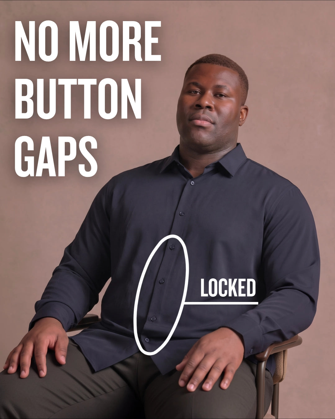 Black man sitting on a chair wearing a navy long-sleeve dress shirt, pointing at the button placket to show no button gap, front view