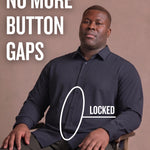 Black man sitting on a chair wearing a navy long-sleeve dress shirt, pointing at the button placket to show no button gap, front view