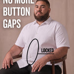 White man sitting on a chair wearing a white short-sleeve dress shirt, pointing at the button placket to show no button gap, front view