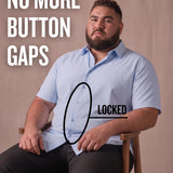 White man sitting on a chair wearing a light blue short-sleeve dress shirt, pointing at the button placket to show no button gap, front view