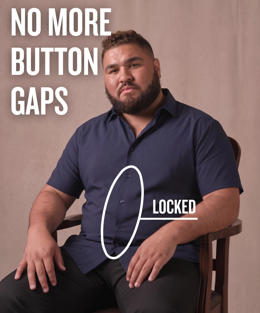 White man sitting on a chair wearing a navy short-sleeve dress shirt, pointing at the button placket to show no button gap, front view
