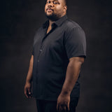 Plus-size Black man trying on NEVER GAPE No-Gap Stretch Dress Shirt in Black, Short Sleeve, side view