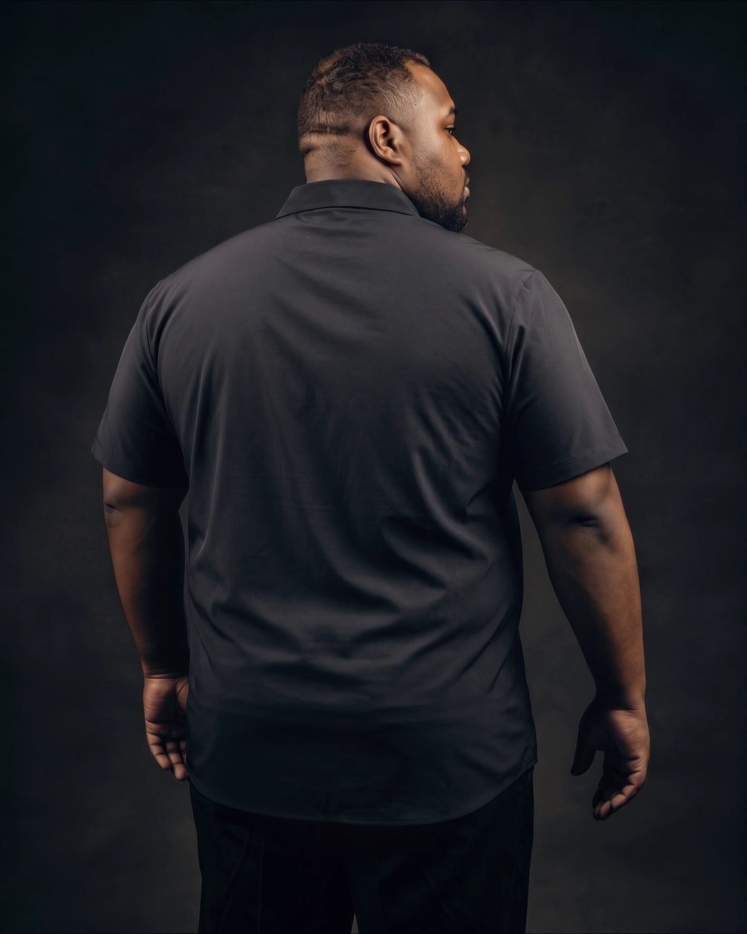 Plus-size Black man trying on NEVER GAPE No-Gap Stretch Dress Shirt in Black, Short Sleeve, back view
