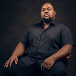 Plus-size Black man sitting in a chair wearing NEVER GAPE No-Gap Stretch Dress Shirt in Black, Short Sleeve