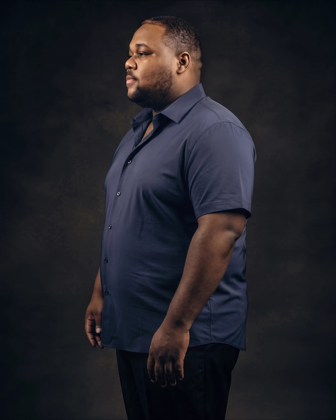 Plus-size Black man trying on NEVER GAPE No-Gap Stretch Dress Shirt in Navy, Short Sleeve, side view