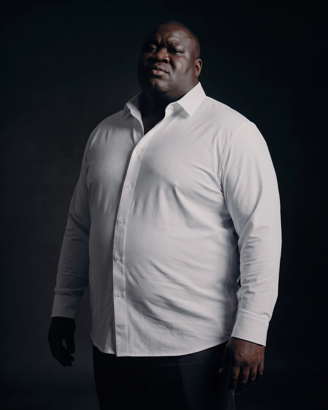 Plus-size Black man trying on NEVER GAPE No-Gap Stretch Dress Shirt in White, Long Sleeve, front view