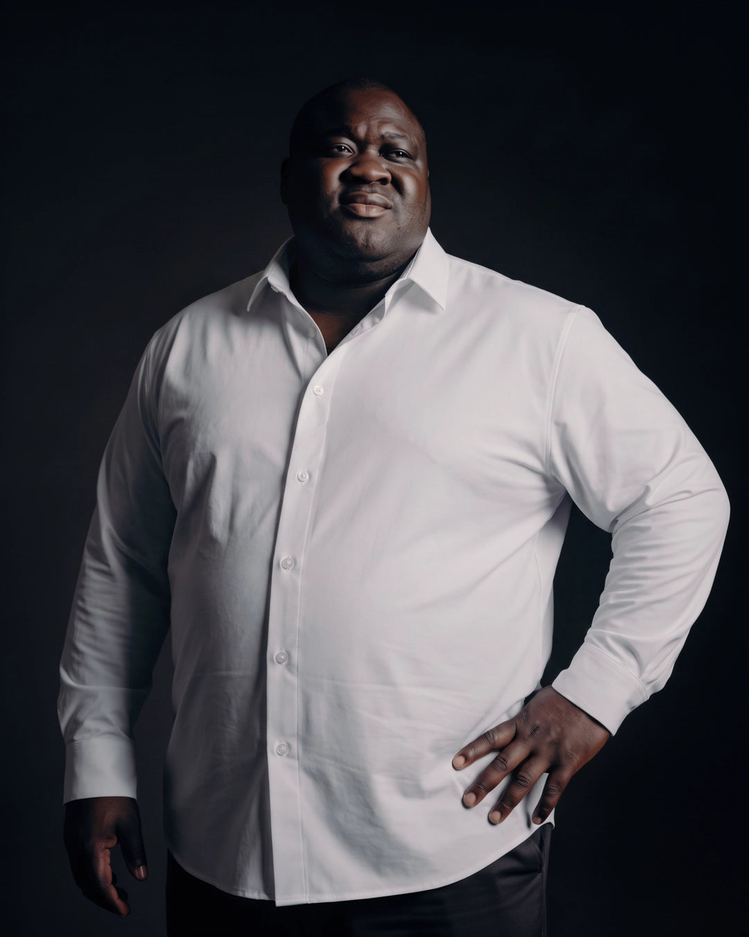 Plus-size Black man trying on NEVER GAPE No-Gap Stretch Dress Shirt in White, Long Sleeve, front view