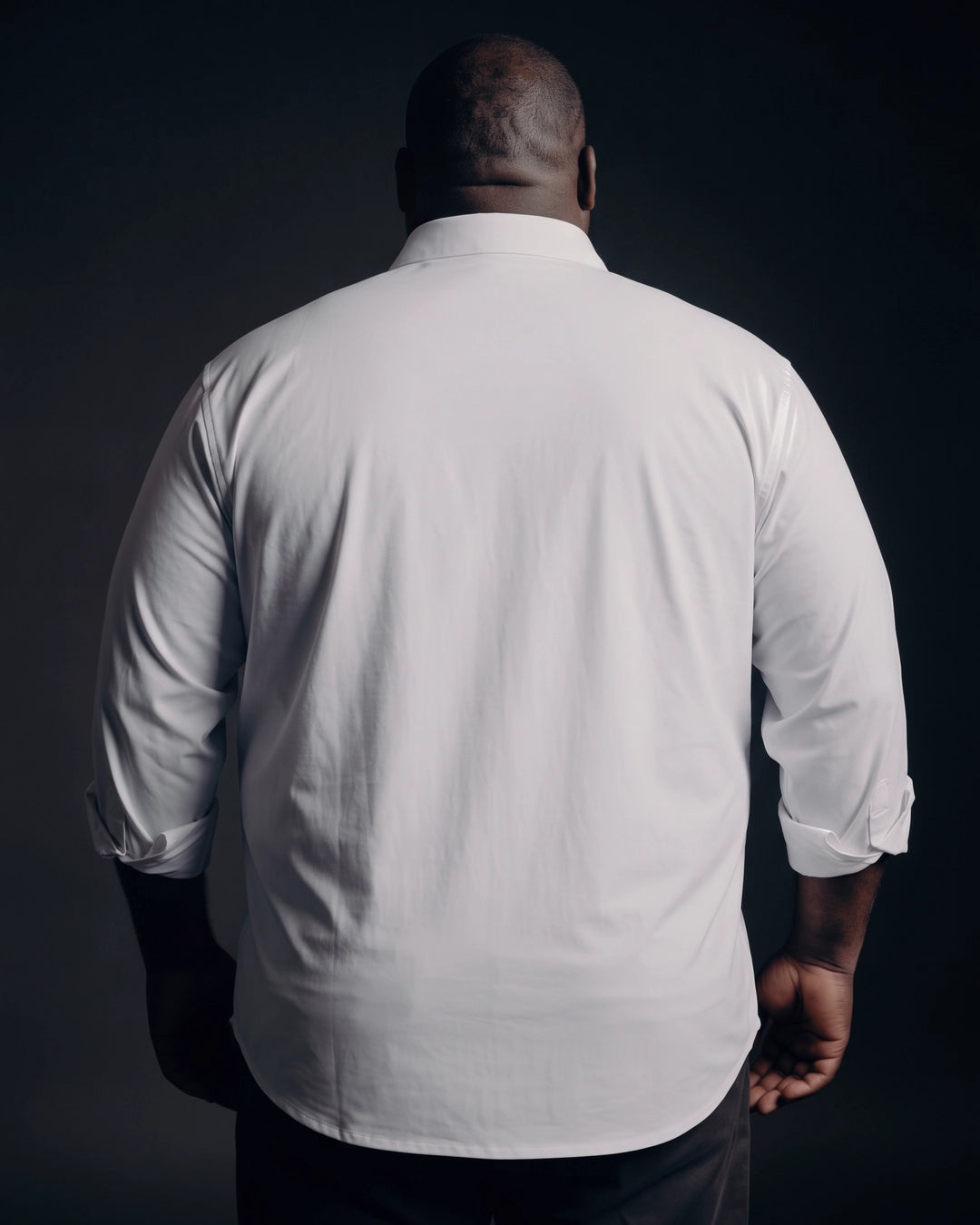 Plus-size Black man trying on NEVER GAPE No-Gap Stretch Dress Shirt in White, Long Sleeve, back view