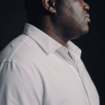 Plus-size Black man trying on NEVER GAPE No-Gap Stretch Dress Shirt in White, Long Sleeve, side view