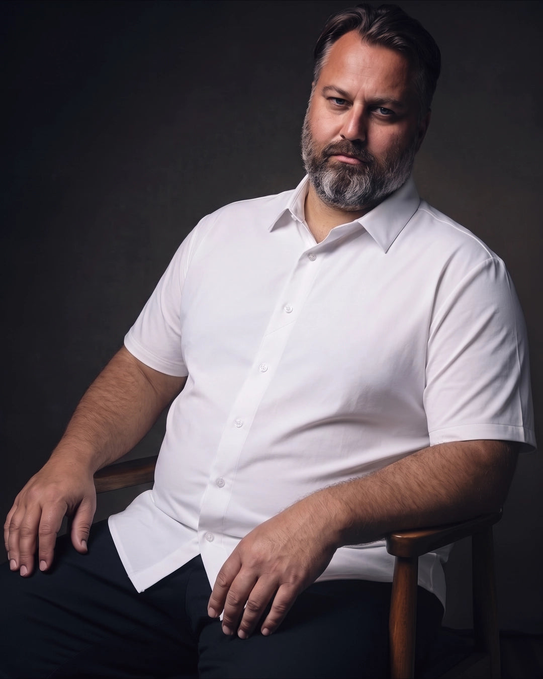 Plus-size white man sitting in a chair wearing NEVER GAPE No-Gap Stretch Dress Shirt in White, Short Sleeve