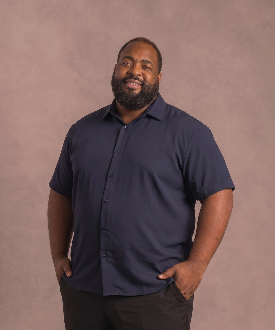 Black man wearing a navy short-sleeve dress shirt, front view