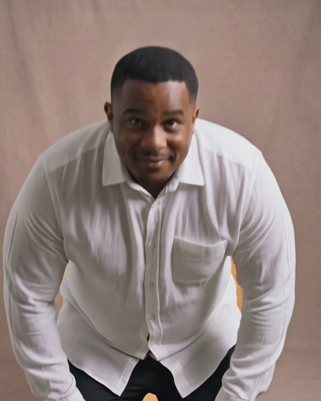 Before and after comparison video of a man sitting down in a regular dress shirt versus a Never Gape dress shirt, demonstrating button gap prevention.